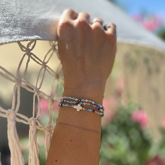 Bracelet 3 tours aux nuances de bleu avec croix blanche porté au poignet
