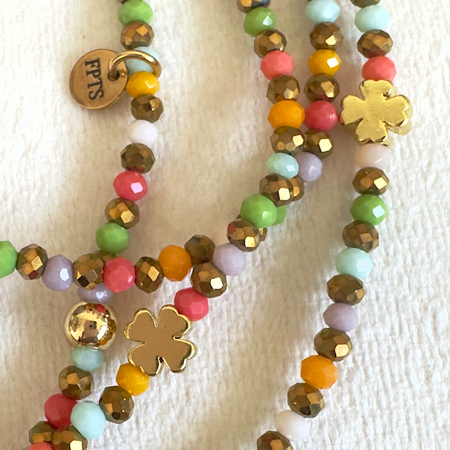 Zoom sur les perles en verre du sautoir Candy Pop, aux couleurs acidulées jaune, turquoise, corail et doré.