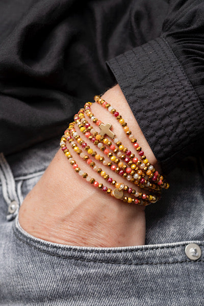 Sautoir Sunset Croix Dorée porté en manchette avec perles facettées multicolores et croix dorée centrale