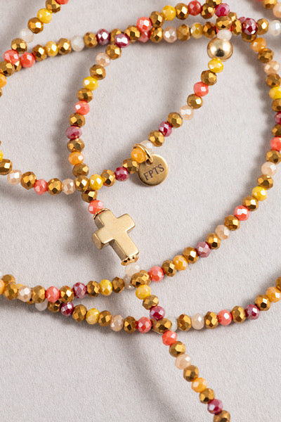 Gros plan du sautoir Sunset Croix Dorée en perles facettées aux tons chauds avec croix dorée centrale