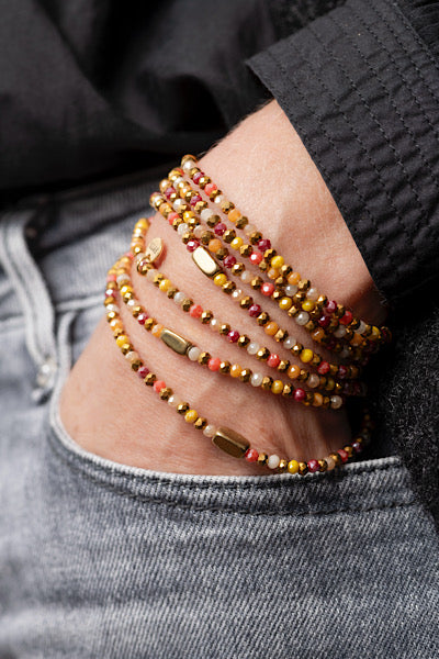 Sautoir Sunset Lingots Dorés porté en manchette avec perles facettées aux tons chauds et lingots dorés