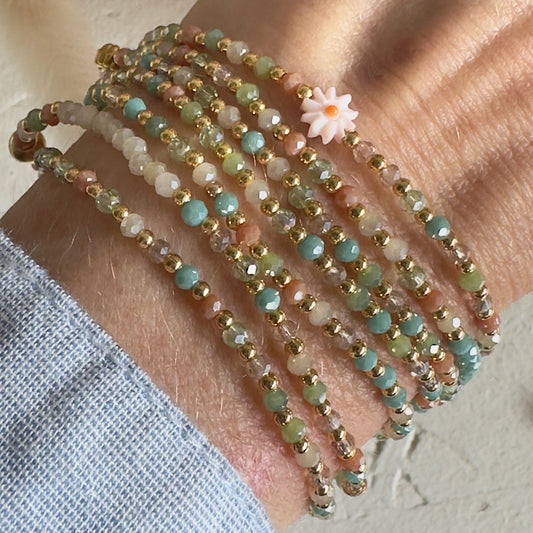 Sautoir Fiorella porté en manchette 7 tours, perles de verre fines aux tons pastel, détail marguerite dorée