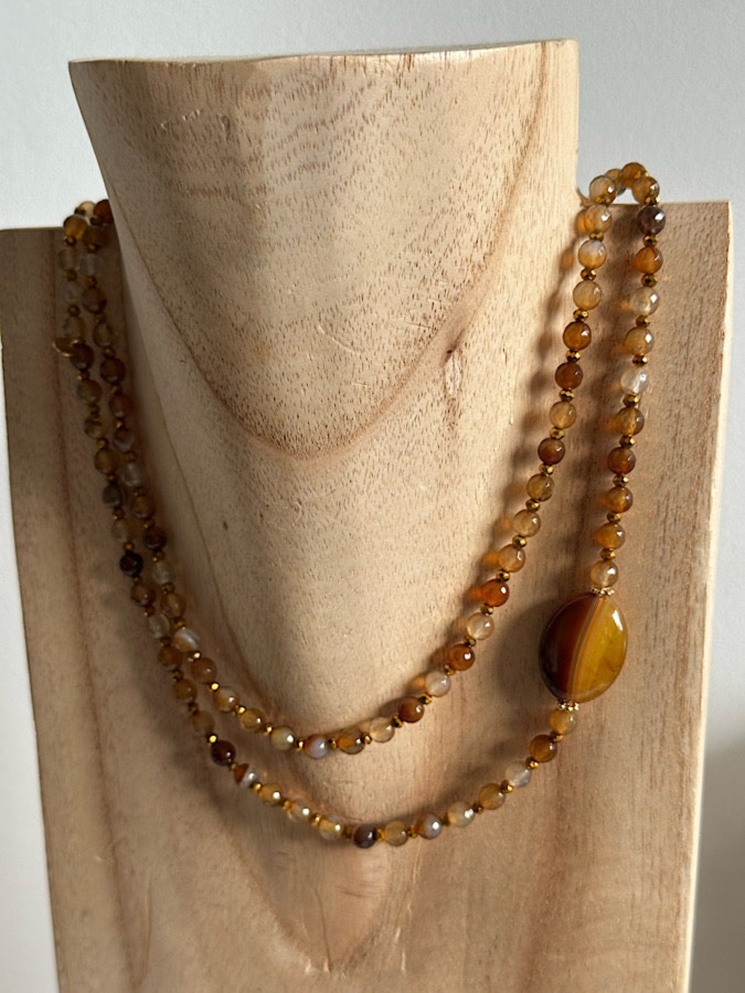 Détail supplémentaire du sautoir Anatole en perles 6mm agate rouge et dorée, vue rapprochée.