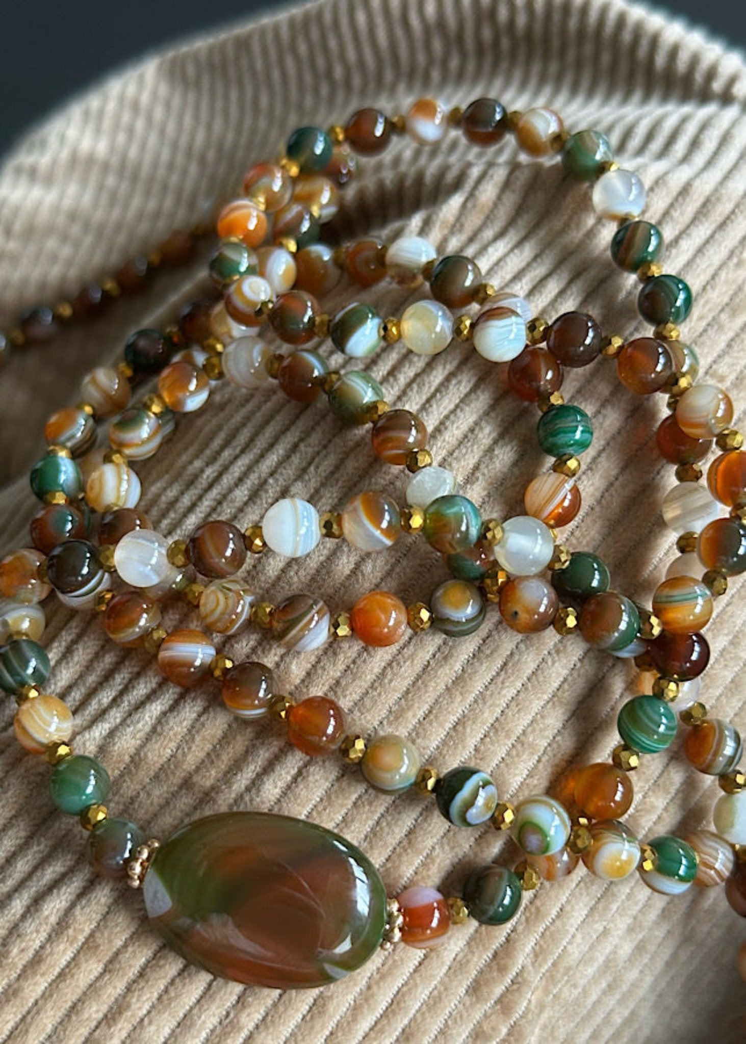 Détail du sautoir Joseph en perles 6mm agate brune et dorée