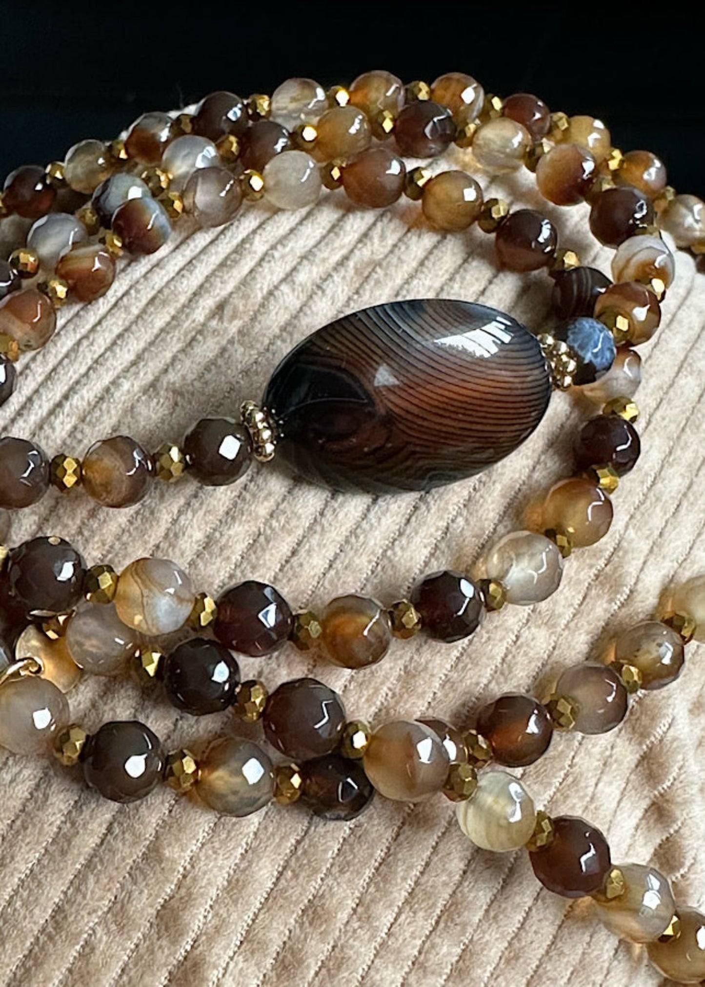 Détail du sautoir Marcel en perles 6mm agate noire et dorée.