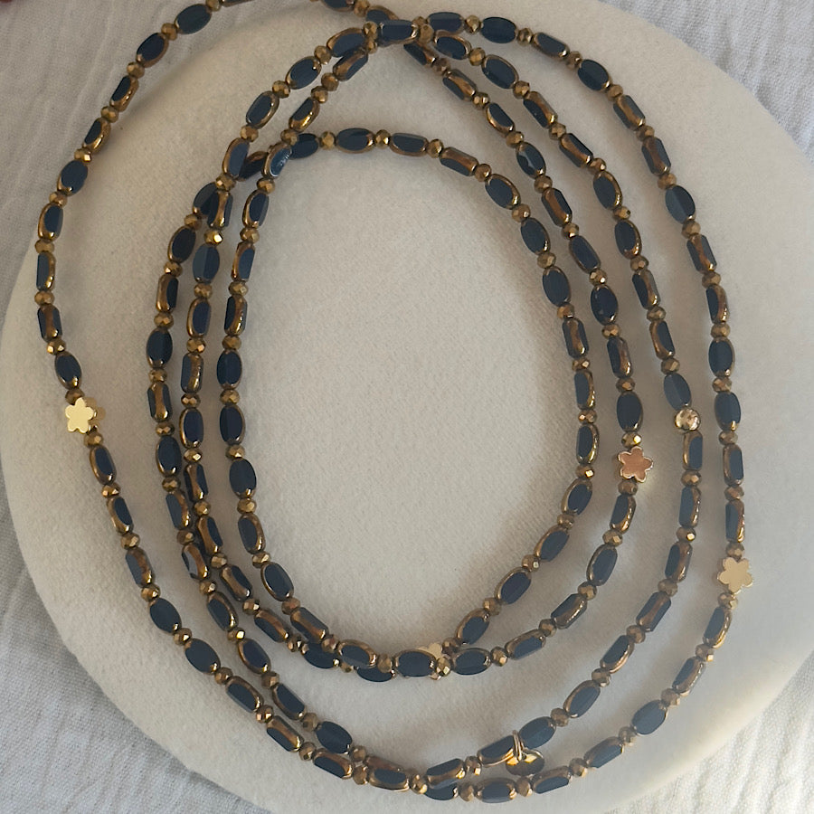 Détail des perles de verre bleu marine du sautoir Minuit Solaire Fleurs Dorées, pour un effet profond et sophistiqué.