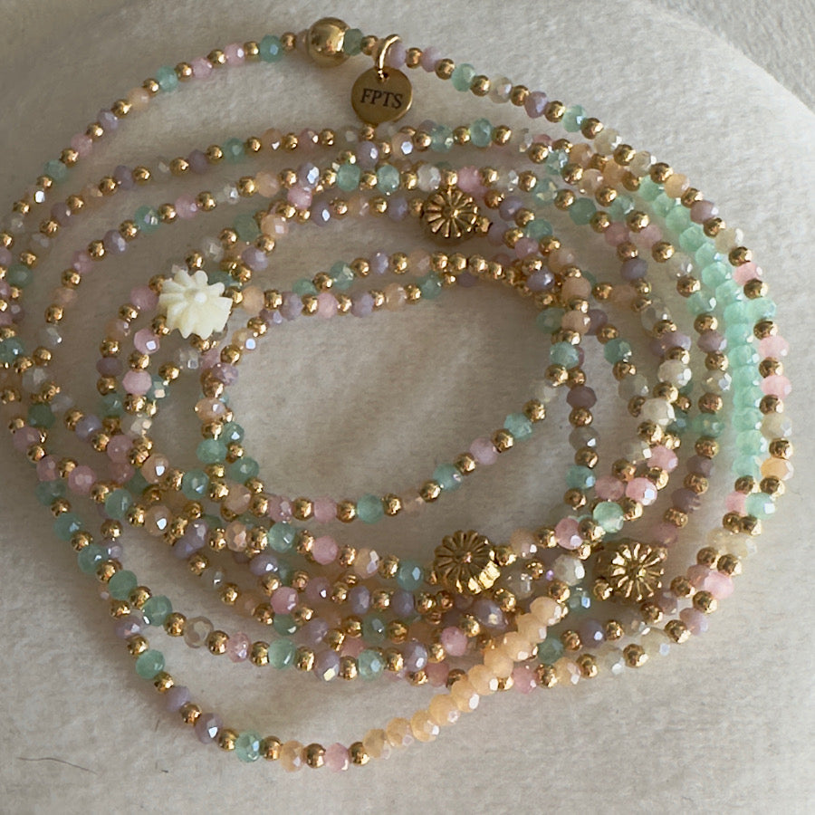 Albella transformé en ras de cou, dévoilant un effet structuré et élégant avec ses perles fines couleur pêche et sa marguerite dorée en coquillage pastel
