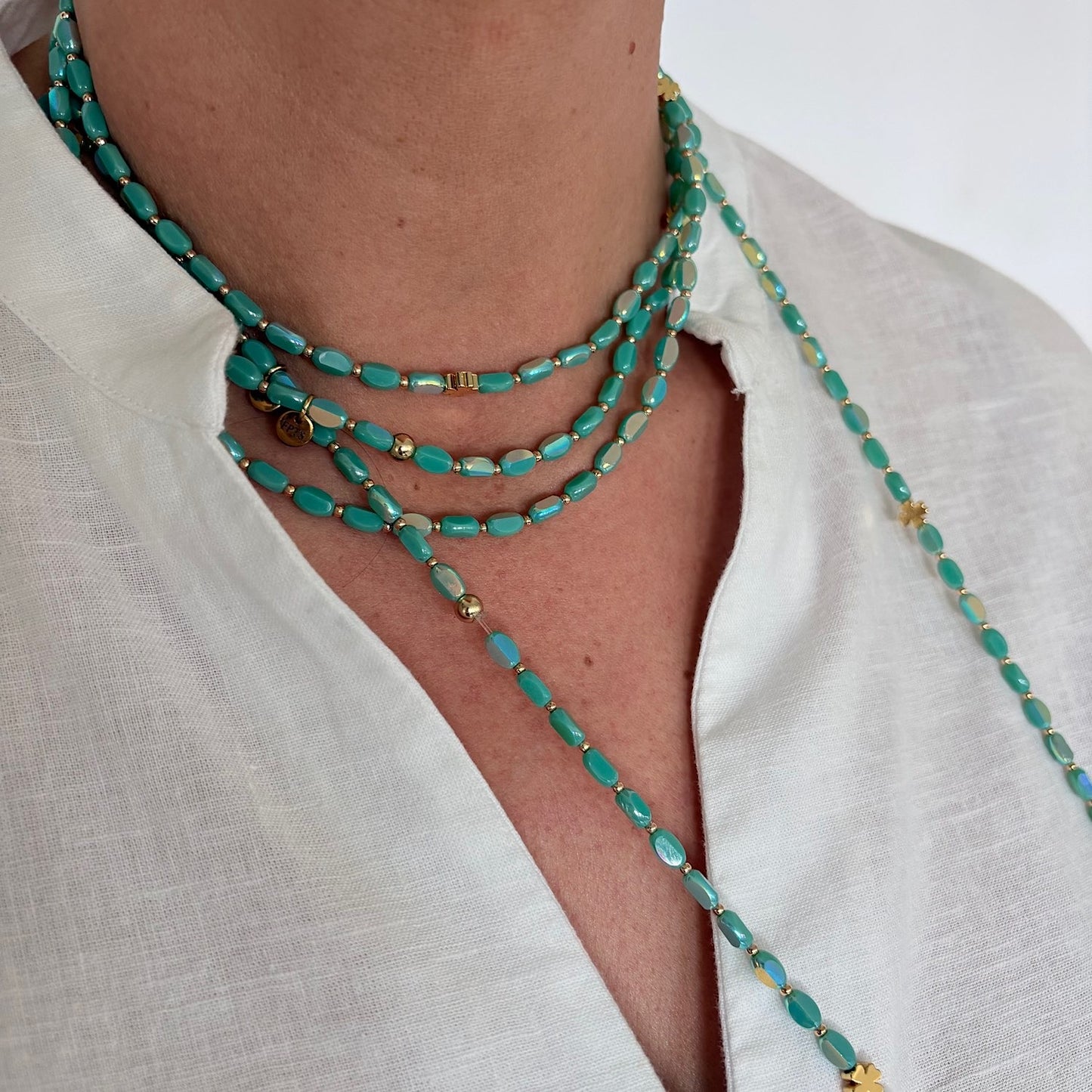 sautoir ovale solaire turquoise en perles de verre porte en collier sur chemise blanche