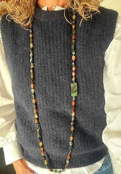 Sautoir Sienna porté, bijou unique en agate torsion aux teintes ambrées et vert mousse, monté sur fil résistant.