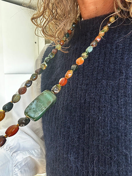 Sautoir Sienna porté sur pull bleu, bijou unique monté sur fil résistant, en agates torsion aux reflets verts et orangés - FAIS PAS TA STEPH