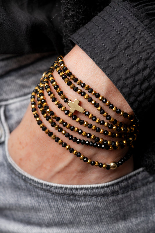 Sautoir Vince Croix Dorée en perles de verre noires avec croix dorée intégrée au centre, porté en sautoir long