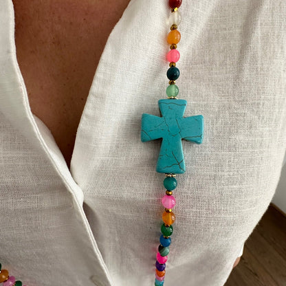 Détail croix turquoise du sautoir Colette multicolore en agate naturelle porté sur blouse blanche, bijou fait main
