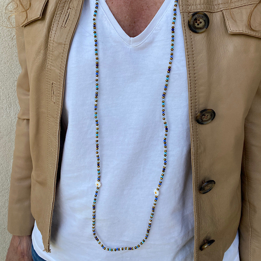 Sautoir en perles bleues et dorées porté en collier long
