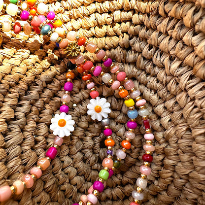 Zoom sur les perles colorées et la marguerite en coquillage du sautoir Gribouillis