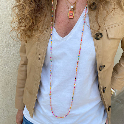 Sautoir Gribouillis porté en collier long, perles multicolores et marguerite en coquillage