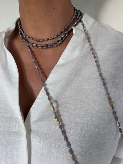 Sautoir en perles lila avec trèfles dorés porté en ras de cou et sautoir