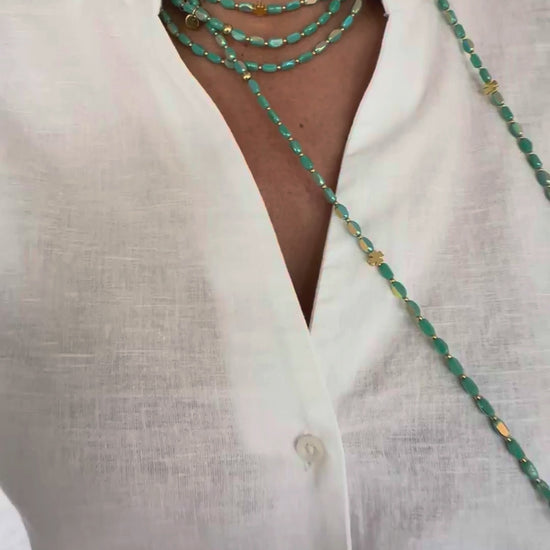 sautoir emeraude solaire en perles de verre porte en collier sur chemise blanche ✨