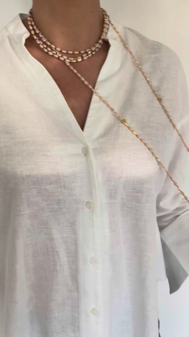 Sautoir Ovale Opaline FAIS PAS TA STEPH porté en collier et manchette, bijou modulable en perles ovales opalines avec trèfles dorés.