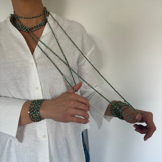 Sautoir Azur Solaire lingots dorés porté en collier long et manchette en perles turquoise et éléments dorés