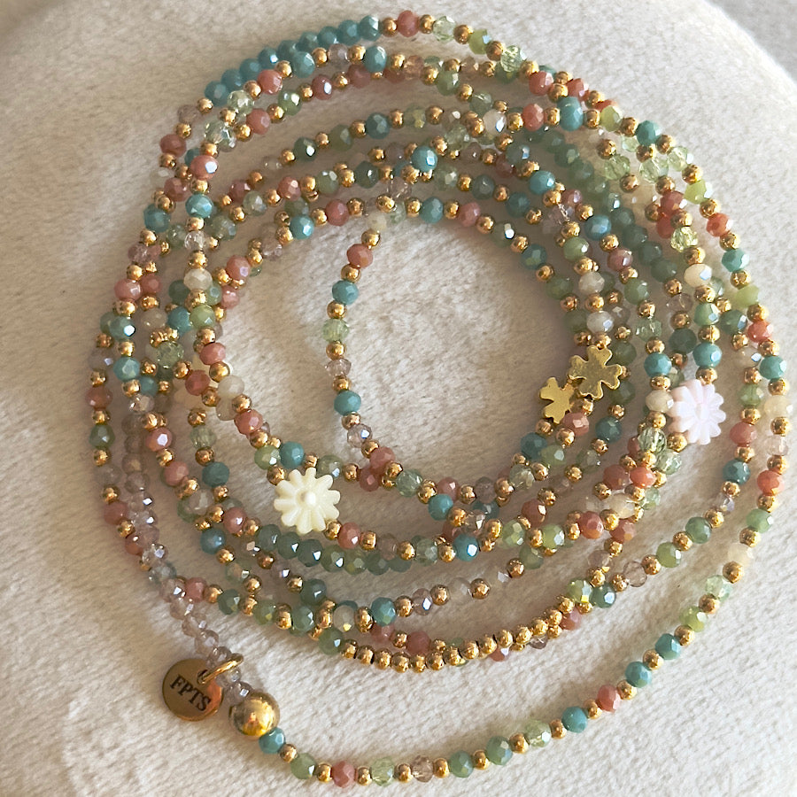 Fiorella transformé en ras de cou, dévoilant un effet structuré et élégant avec ses perles de verre fines et sa marguerite dorée en coquillage pastel