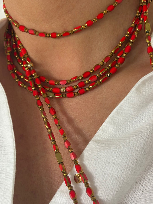 sautoir corail solaire trefles dores en perles de verre rouge orange porte en collier sur chemise blanche